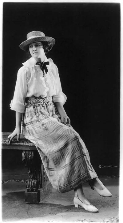 [Woman modeling skirt, blouse, hat and shoes]