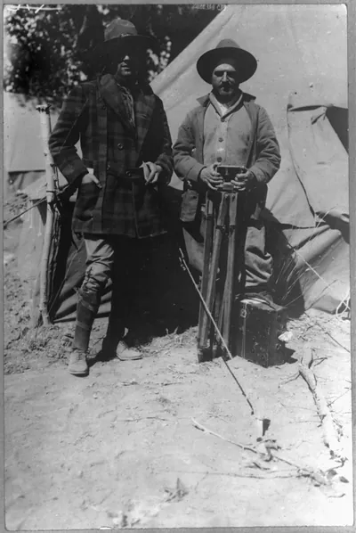[Tracy Mathewson and William Fox, news photographers, in camp with movie camera]