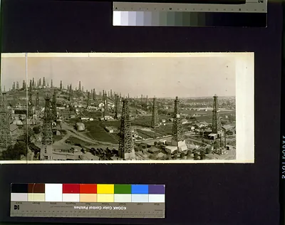 Panoramic view of oil derricks over a town