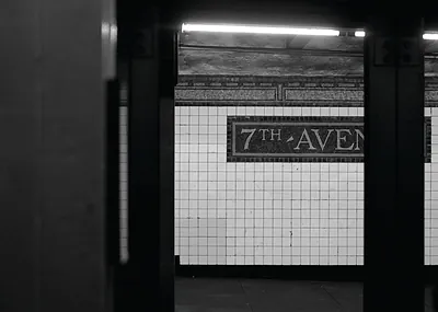 7th Avenue subway platform with white tile wall sign