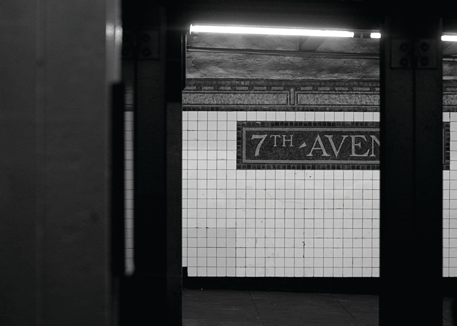 7th Avenue subway platform with white tile wall sign — historic image