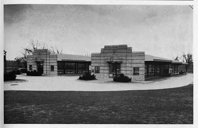 Brick market building with covered side wings and circular drive