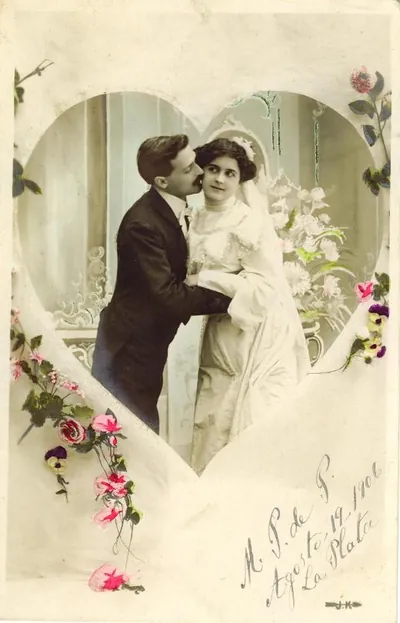 Hand-colored postcard of a wedding couple in a heart frame