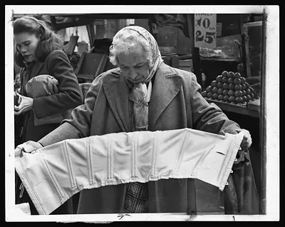 Woman examining a corset at a market stall