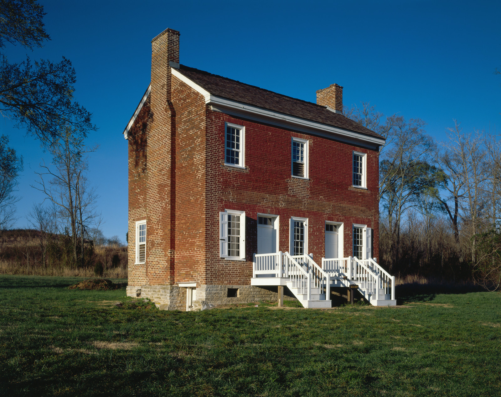 Two-story brick house with white porch and steps — historic image