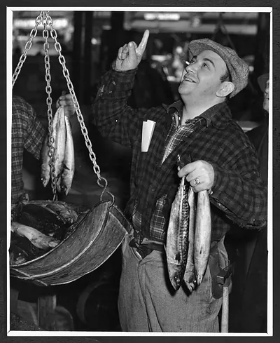 Man weighing fresh mackerel at a fish market