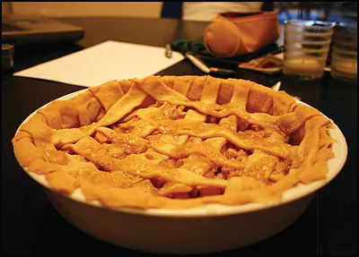 Apple pie with lattice crust in a white dish