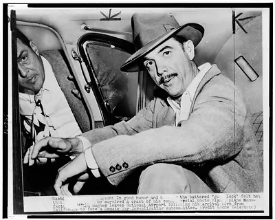[Howard Hughes, seated in automobile at National Airport, facing front]