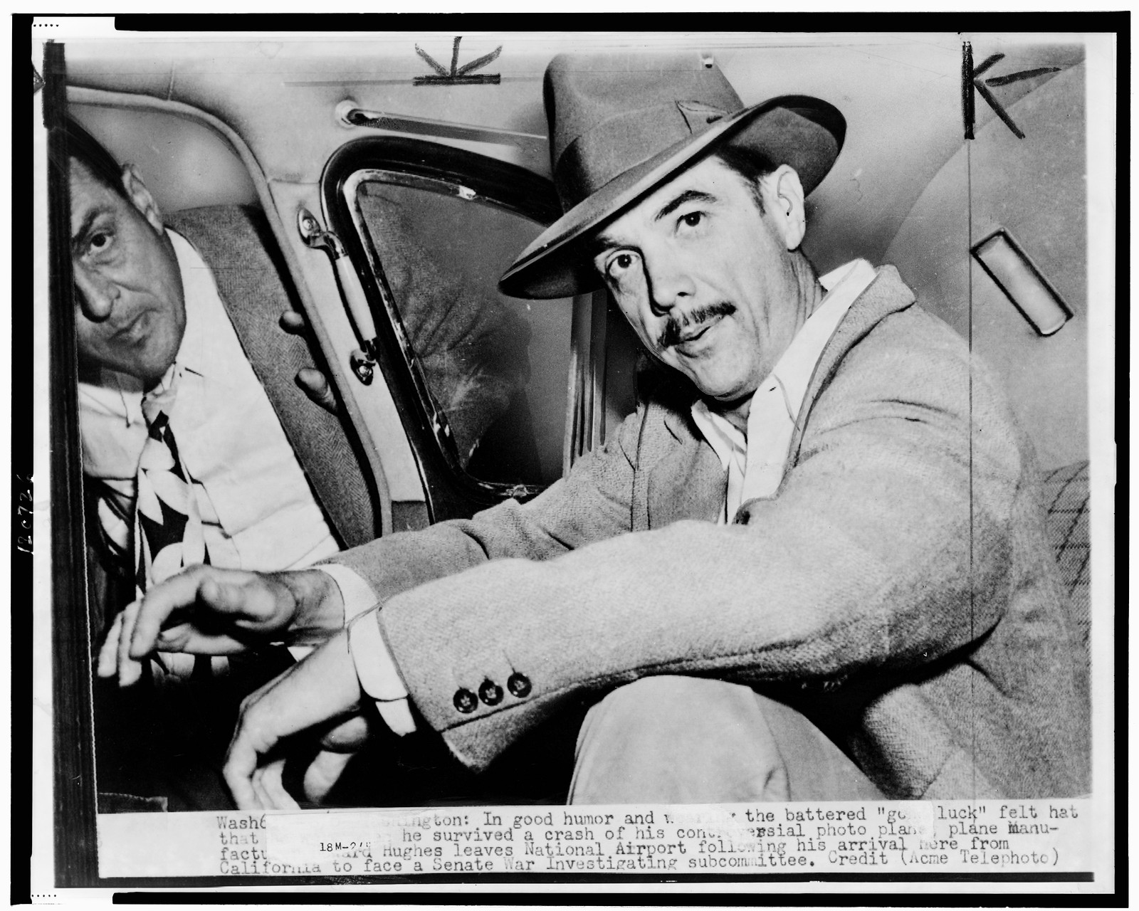 [Howard Hughes, seated in automobile at National Airport, facing front] — historic photograph