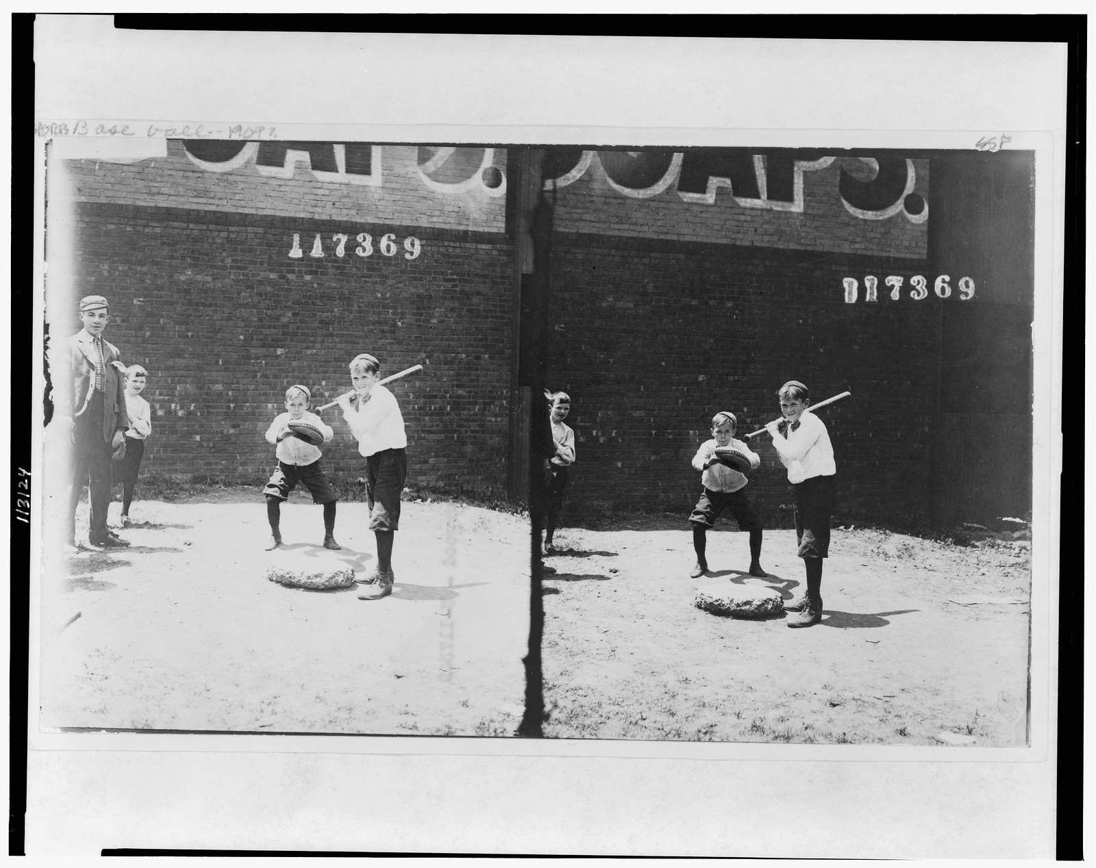 [Boy holding baseball bat and boy wearing catcher's mitt], [between 1900 and 1910] — historic photograph