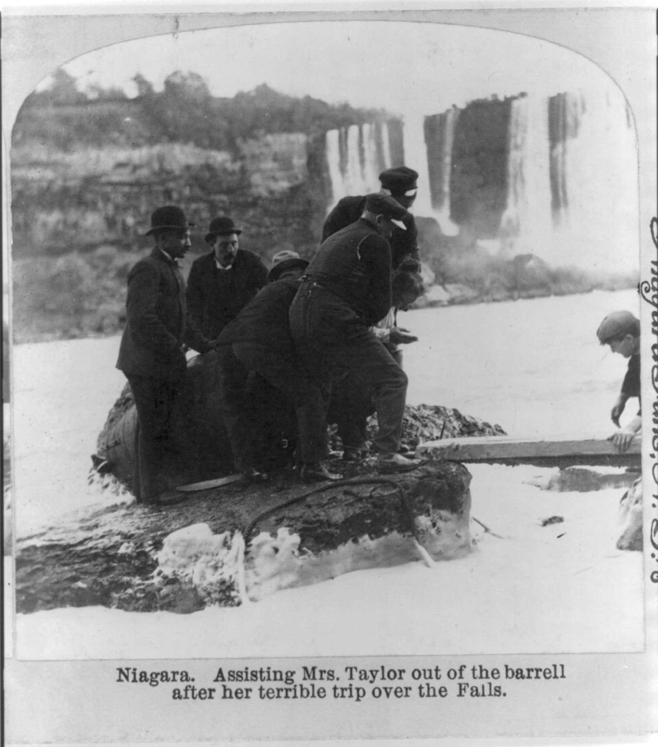 Niagara. Assisting Mrs. [Anna E.] Taylor out of the barrell [sic] after her terrible trip over the falls, c1901. — historic photograph