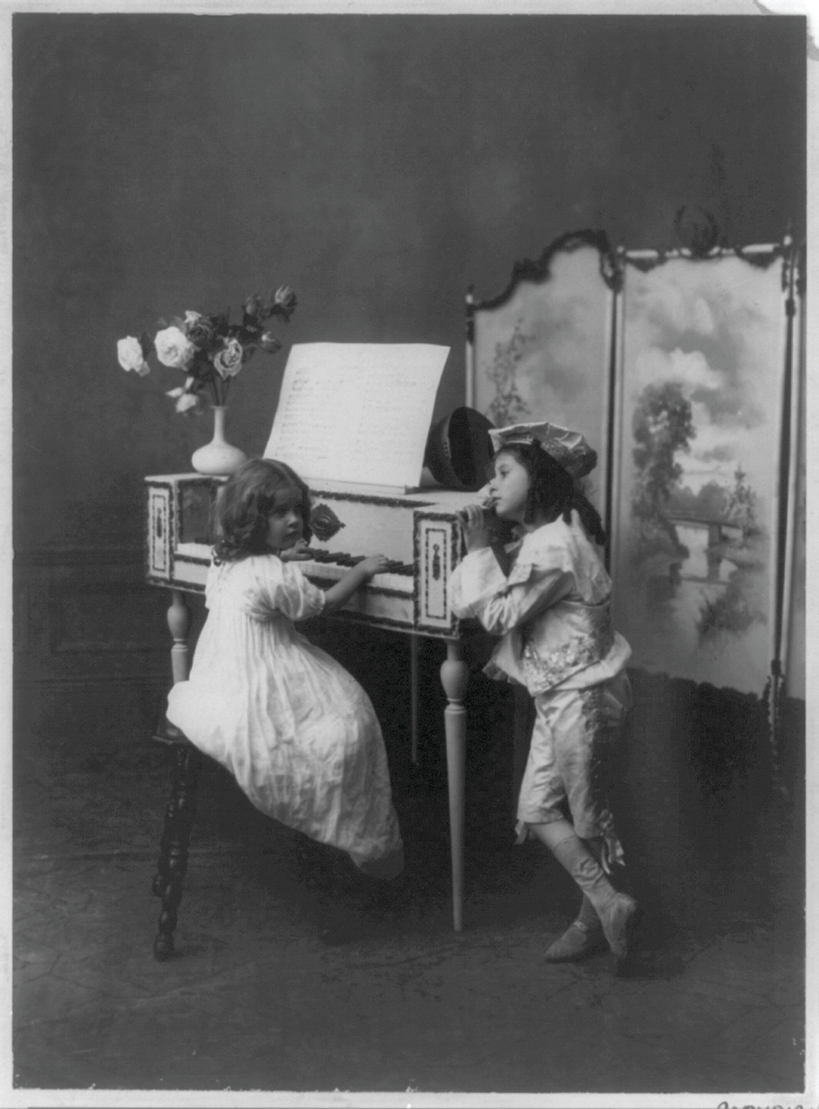 Two children in costume beside a spinet, photograph — historic photograph