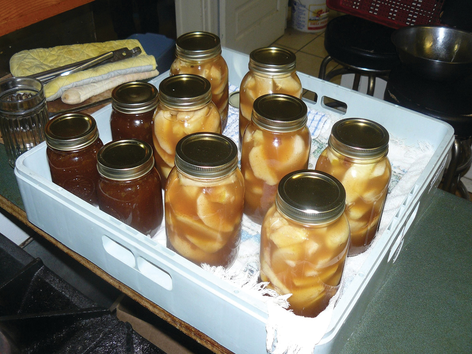 Home-canned apple slices and fruit preserves in glass jars — historic image
