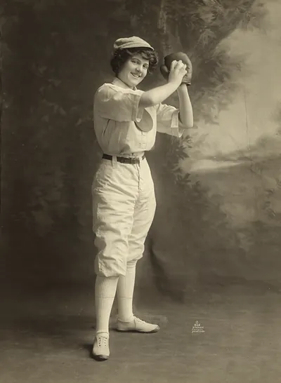 Smiling woman in baseball uniform holding a glove, studio portrait
