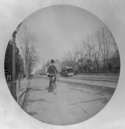 [Man on bicycle on street, Washington, D.C.; horse-drawn streecar in background]