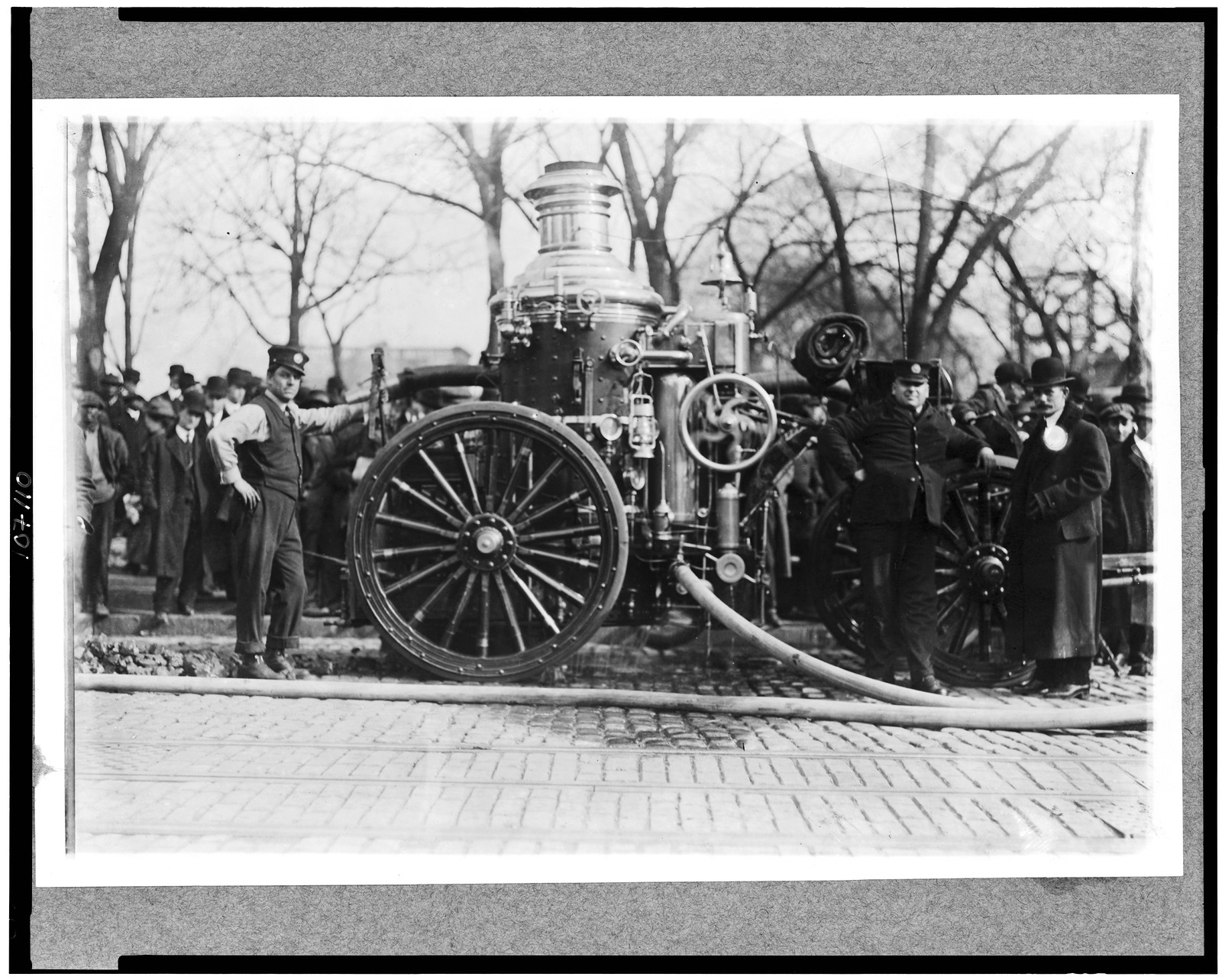 [Two firemen with fire engine], [between 1909 and 1932] — historic photograph