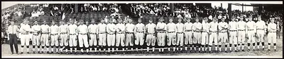 Baseball team in uniform lined up before grandstand, panoramic photograph