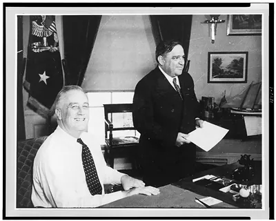 [Franklin D. Roosevelt, half-length portrait, seated at desk, facing right, with Fiorello La Guardia standing alongside]
