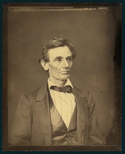 Sepia portrait of a man in dark coat, vest and bow tie