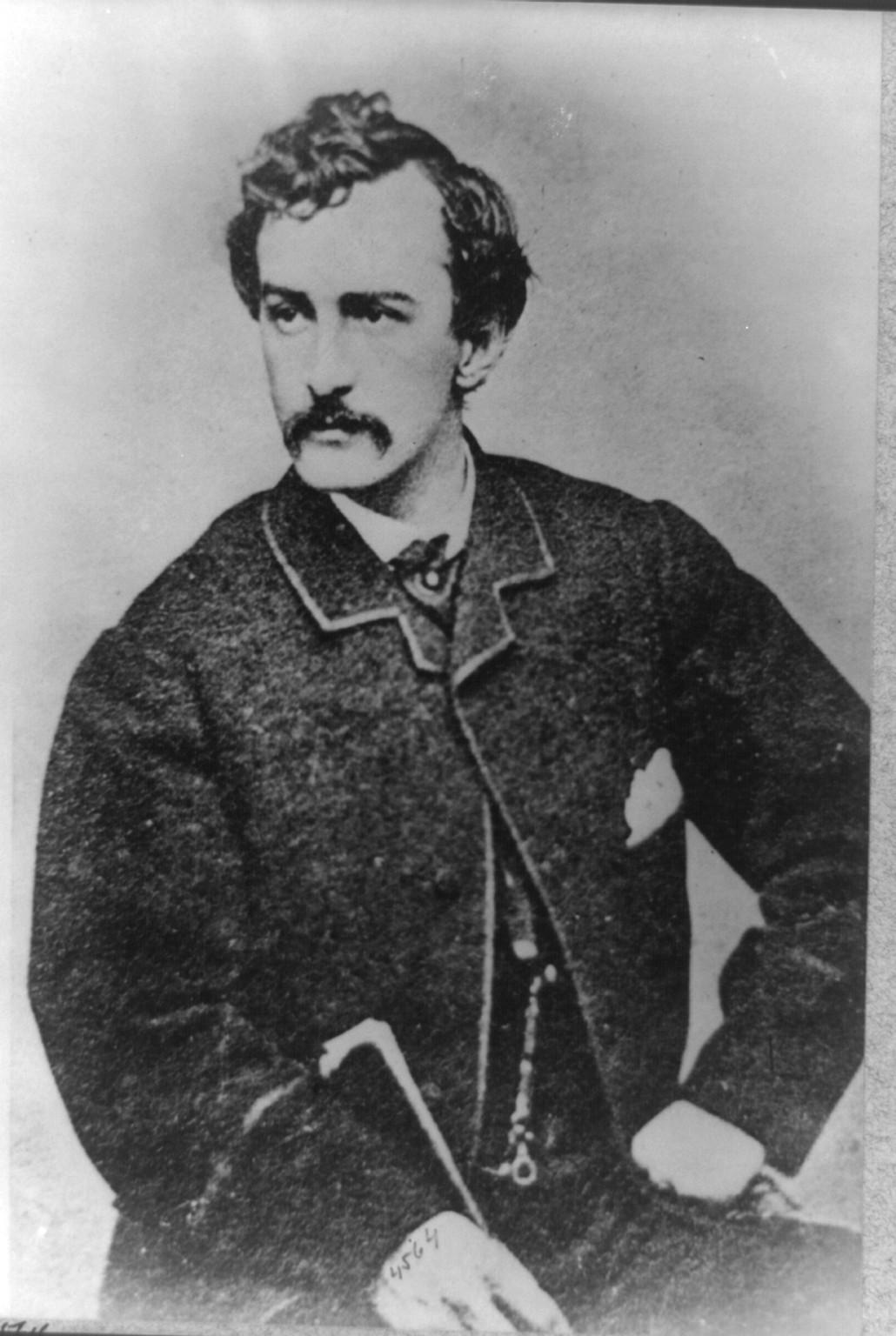 [John Wilkes Booth, half-length portrait, facing left and holding a cane], [between 1860 and 1865] — historic photograph