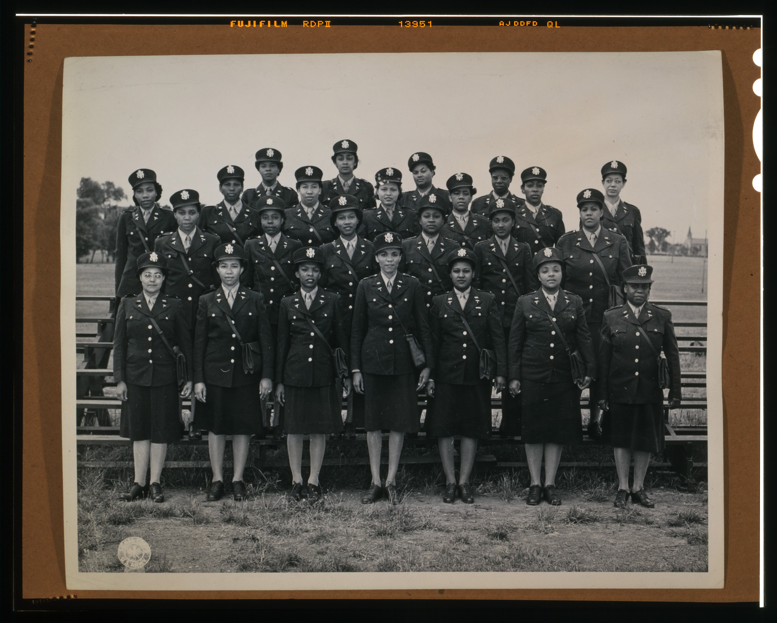 Women in Army Corps uniforms, group portrait on bleachers — historic image