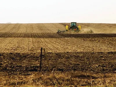 Tractor with planter working a tilled field