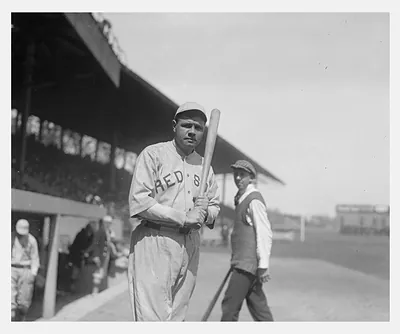 Baseball player in Reds uniform holding a bat