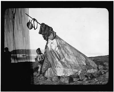 [Tent with Inuit woman standing in doorway, in Arctic regions]