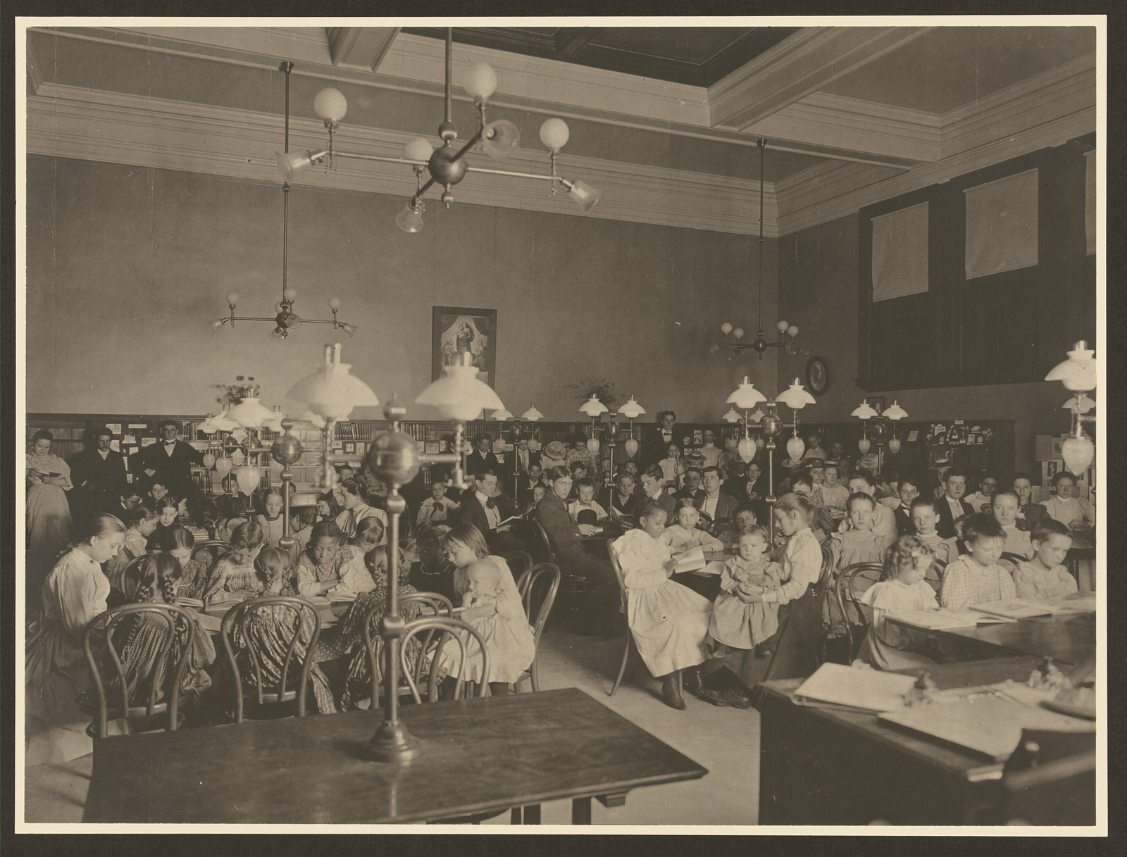 Children at tables in a library reading room, sepia photograph — historic photograph