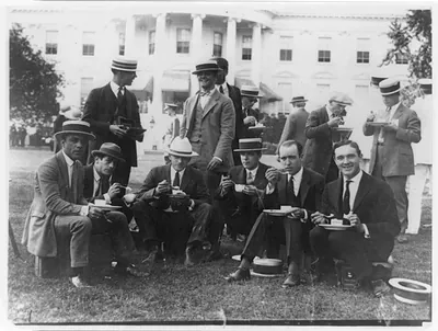 [White House photographers eating on lawn of the White House]