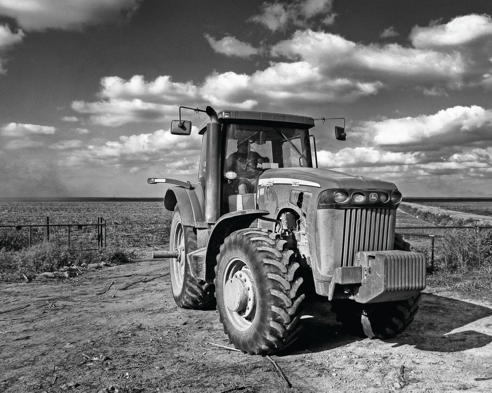 Black and white tractor in a flat field — historic image