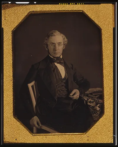 [William Young McAllister, three-quarters length portrait, seated in a chair, arm resting on table with tablecloth]