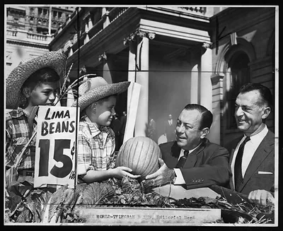 Boys in straw hats with lima beans sign and pumpkin