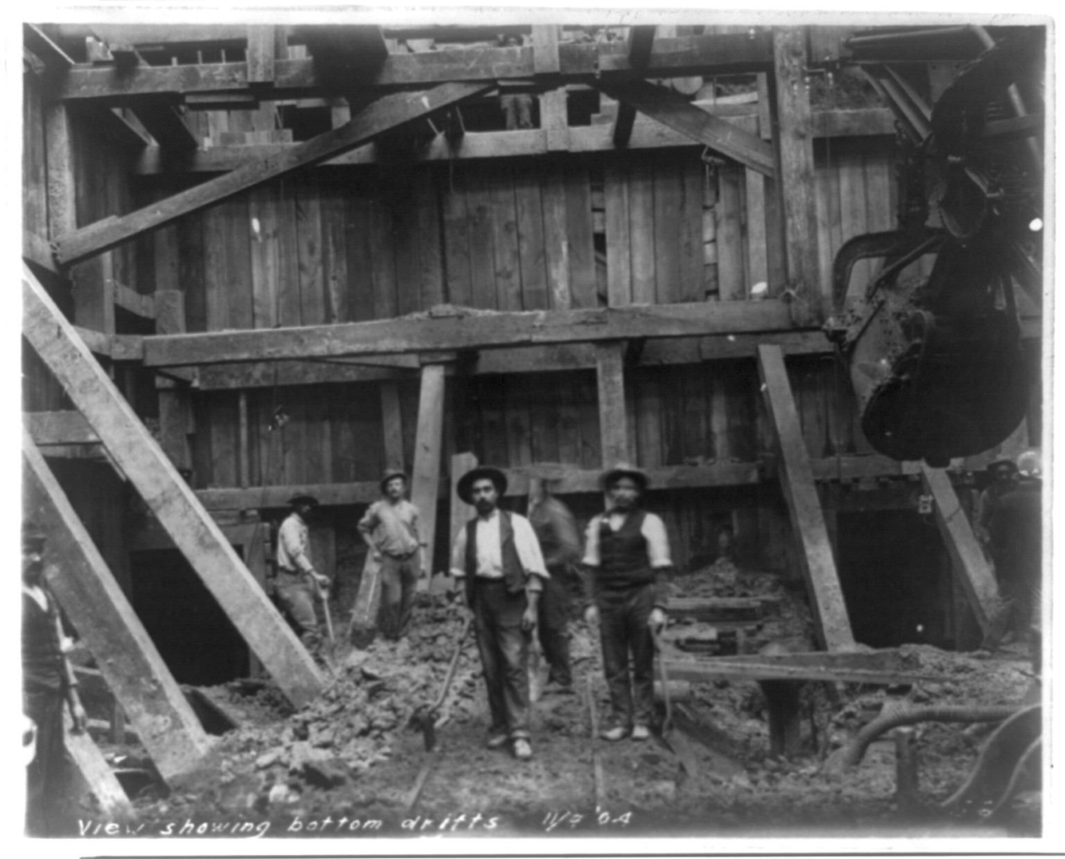 [Railway tunnel construction in Washington, D.C., near Union Station: 7 members of construction crew at bottom of drifts], [between 1904 and 1905] — historic photograph