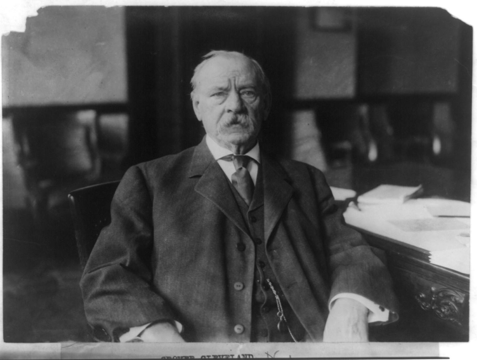 [Grover Cleveland, half-length portrait, seated at desk, facing front], c1908. — historic photograph