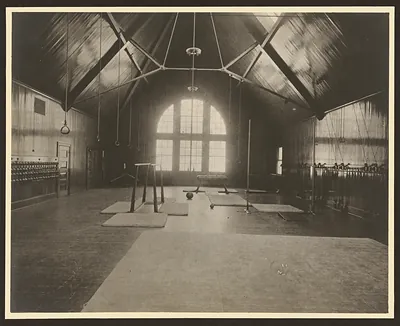 Gymnasium interior with parallel bars, mats and wall rings