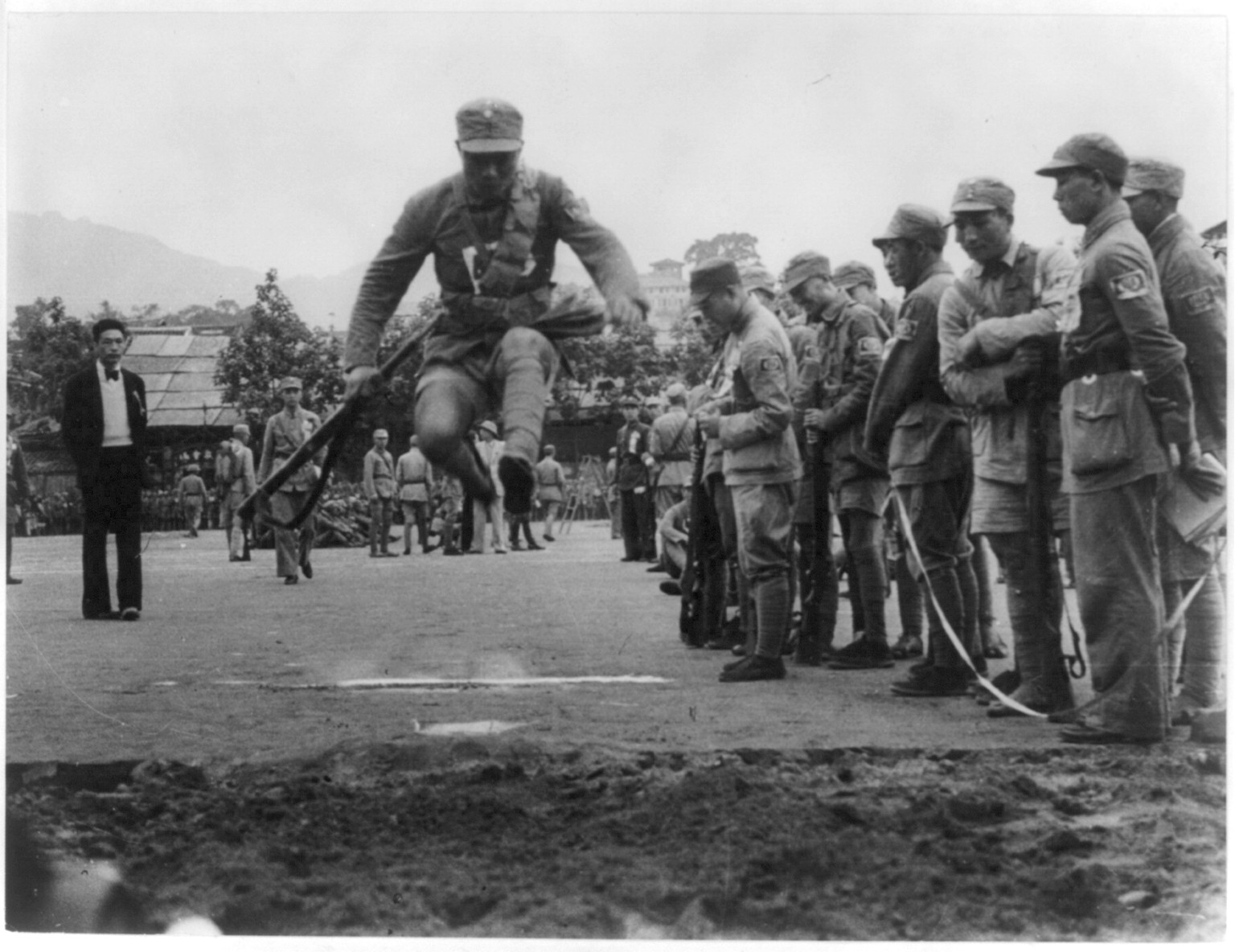 [Chinese soldier making broad jump carrying full equipment. Trining exercise], [between 1938 and 1943] — historic photograph