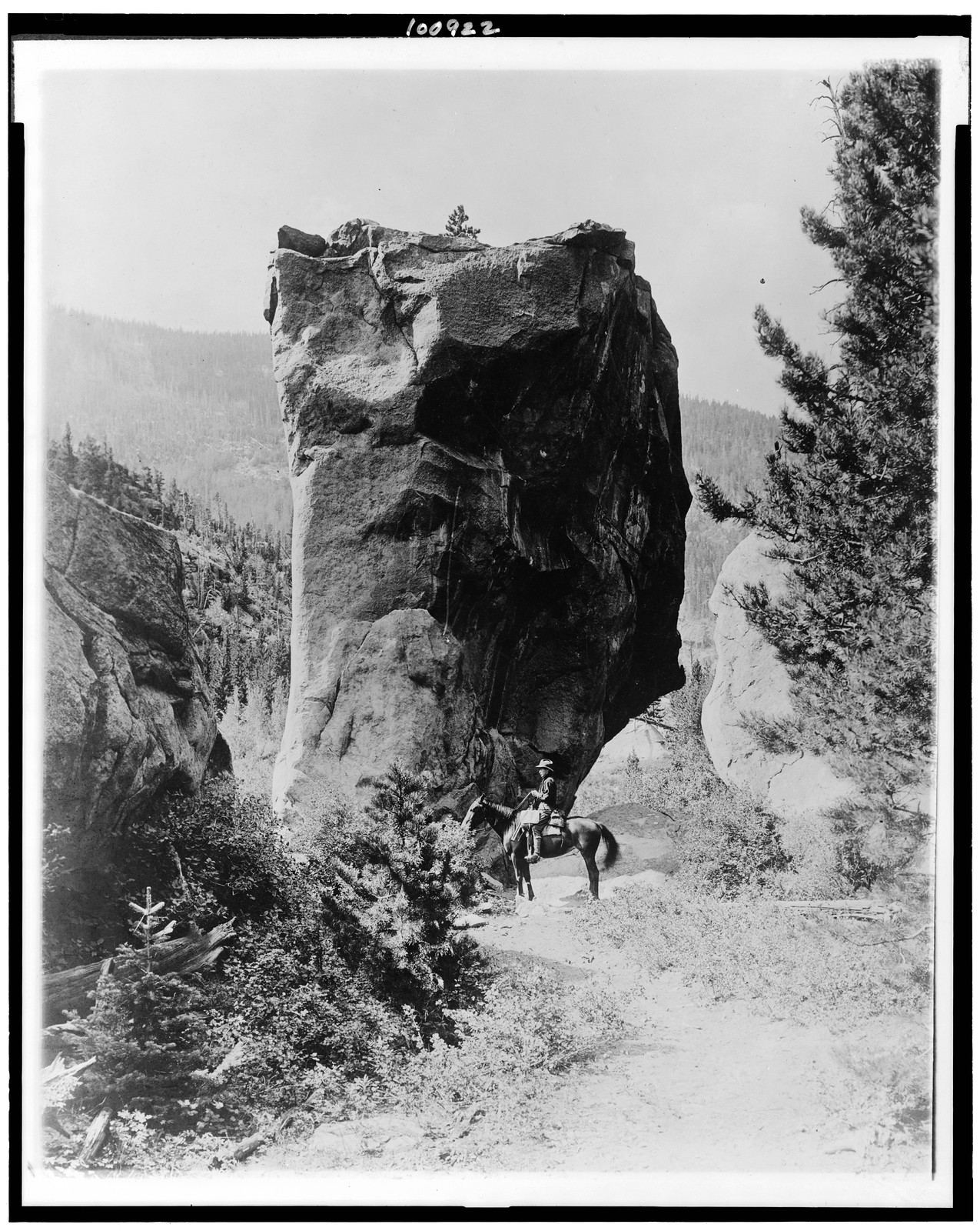 [Man on horseback by butte in Rocky Mountain National Park, Colorado], [between 1909 and 1932] — historic photograph