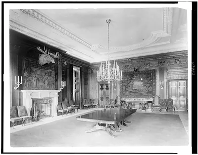 [Interior view of the White House, with moose head over fireplace, and chandelier above table]