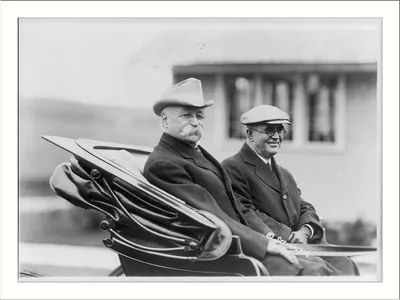 [County or state fair in New England: 2 men in back of open carriage]