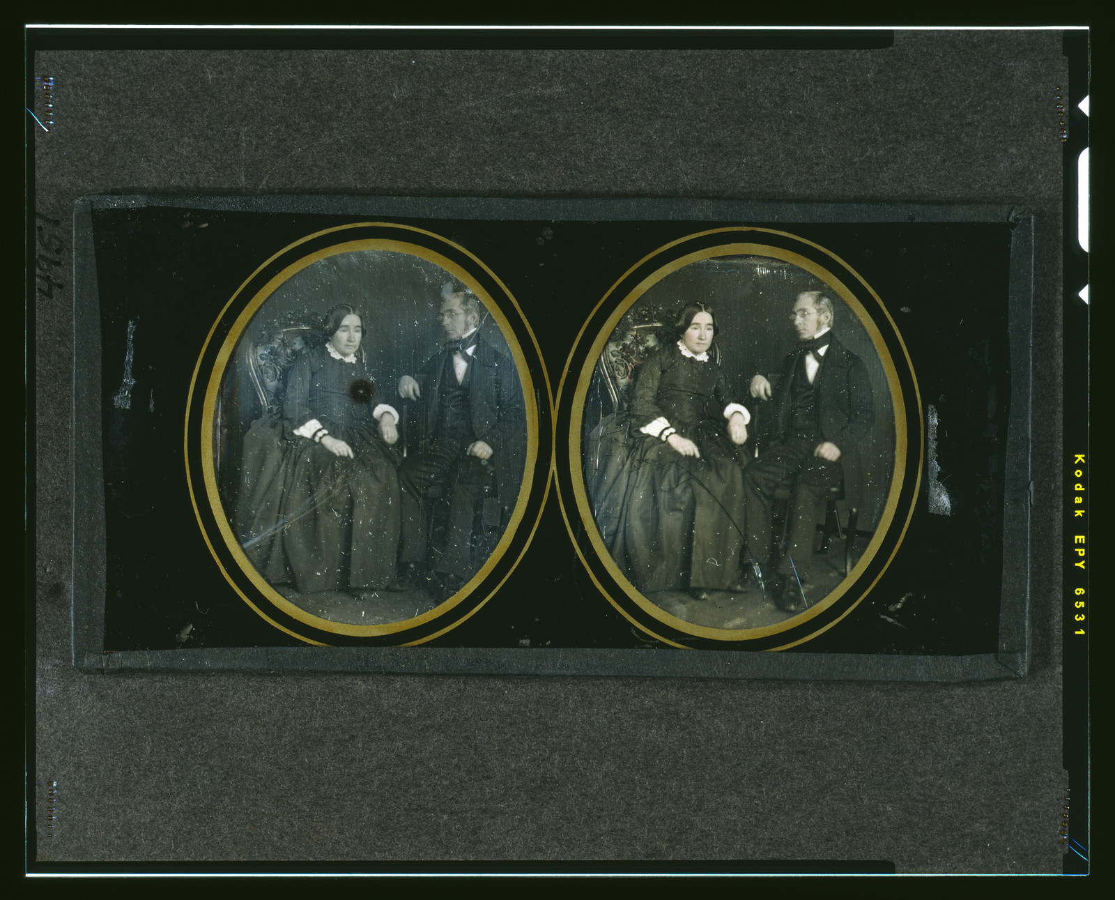 Hand-colored daguerreotype stereo pair of seated woman and standing man, 1850 — historic photograph