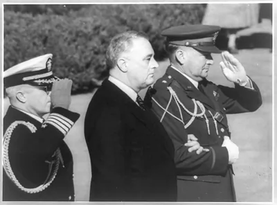 [Franklin D. Roosevelt and two military officers who are saluting]