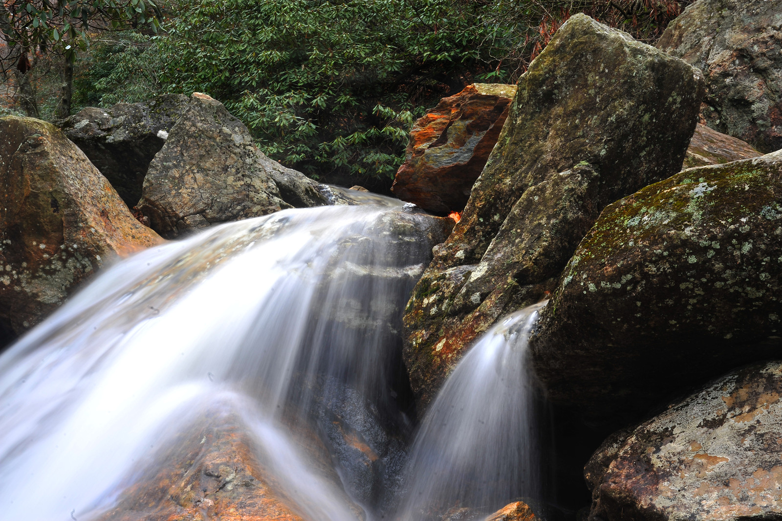 Long-exposure waterfall over mossy boulders — historic image