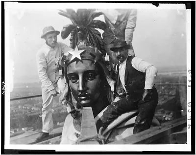 Three Men with Statue of Freedom on Top of the U.S. Capitol [c. 1909–1932]