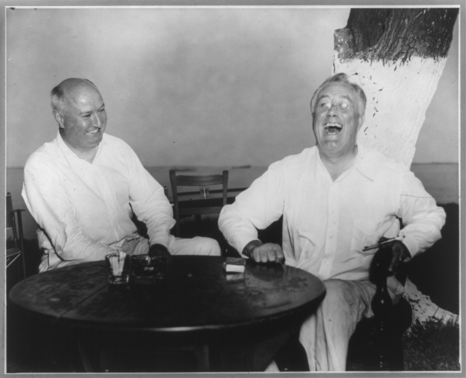 [Franklin Delano Roosevelt, half length, seated at table, facing slightly left, laughing, with James Farley, at Jefferson Island, La.] — historic photograph