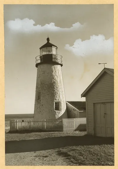 Stone lighthouse with picket fence and shed