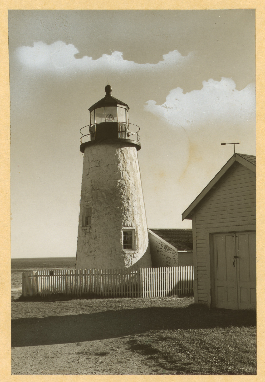 Stone lighthouse with picket fence and shed — historic image