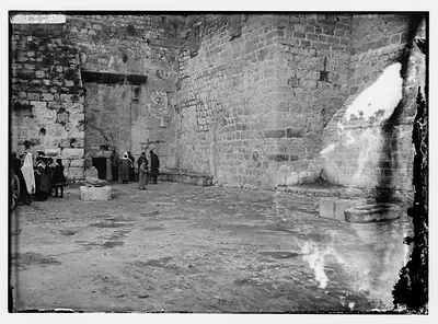 Stone courtyard with figures beside a doorway and wall