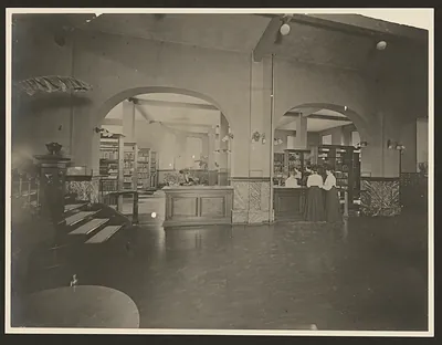 Library interior with arches, bookshelves and circulation desk
