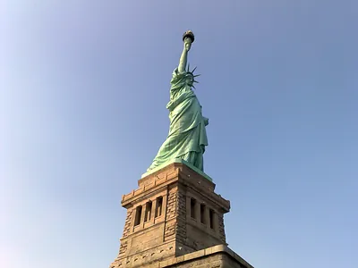 Statue of Liberty seen from below against a clear blue sky